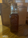 Vintage 1-pound glass honey bottle from Tricounty Farm, showcasing a classic design and golden honey inside.